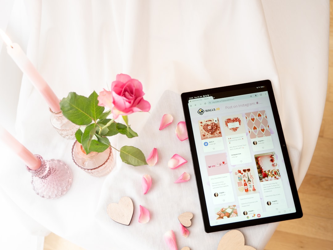 White background with tablet and a romantic setup with candles, hearts and rose petals