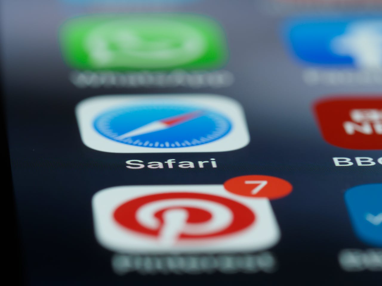 Detailed view of popular apps on a smartphone touchscreen, including Safari, Pinterest, and WhatsApp.