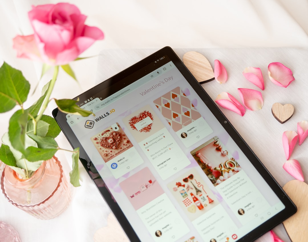 White background with tablet and a romantic setup with candles, hearts and rose petals